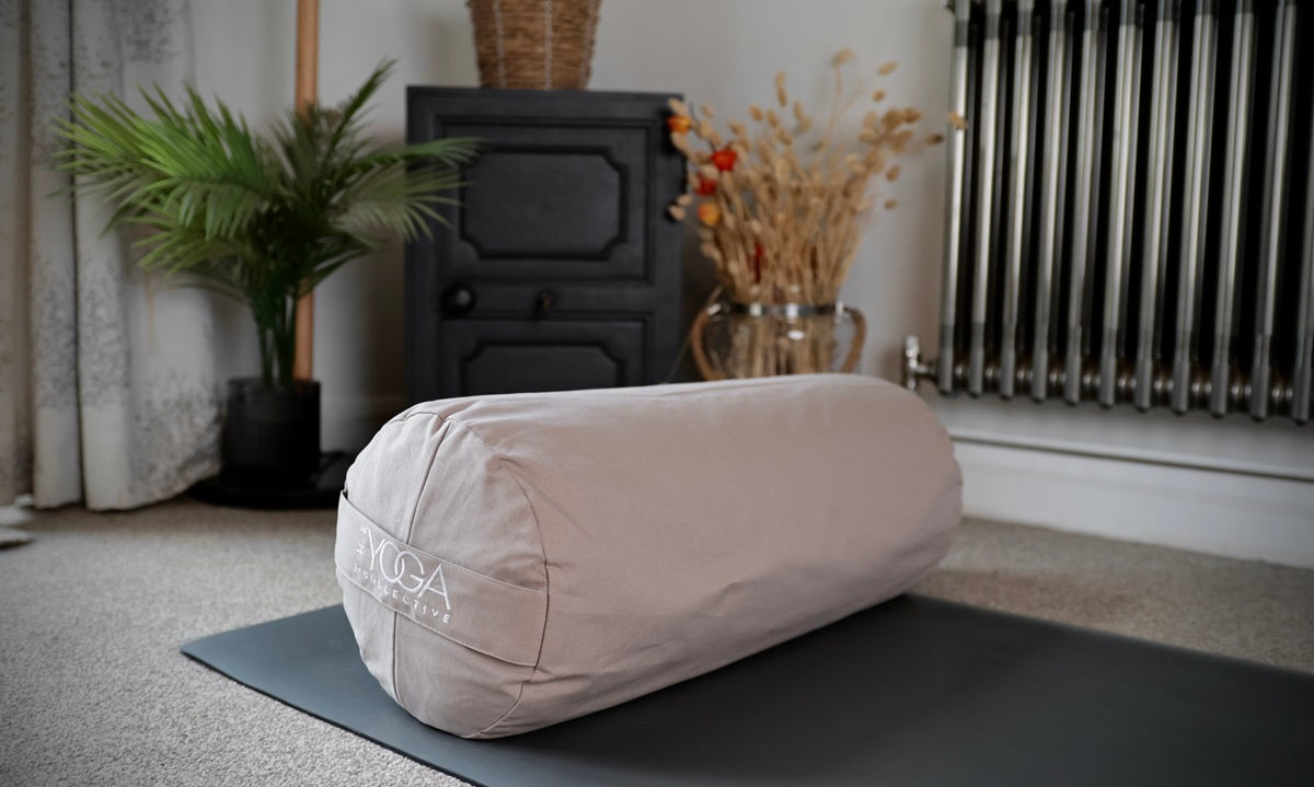 Yoga bolster on a mat, ideal for yoga bolster vs meditation cushion discussions.