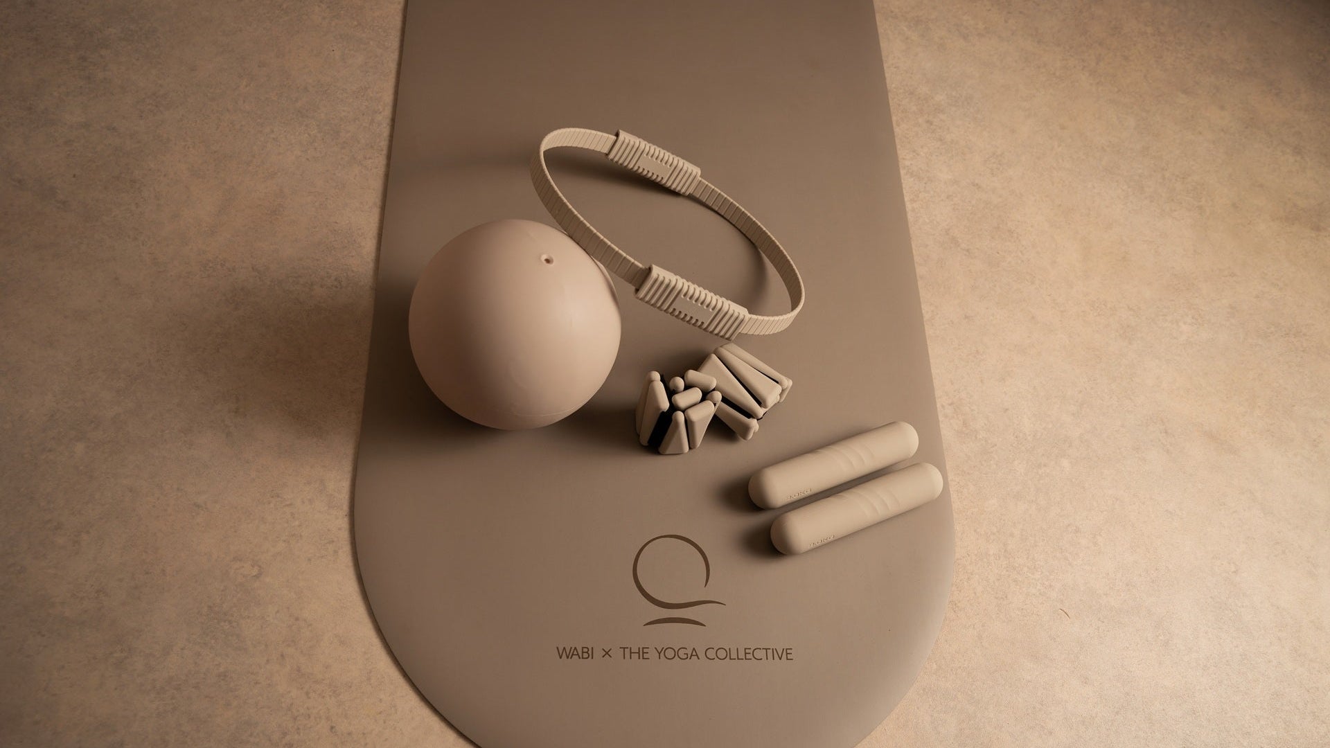 Yoga mat with accessories on a beige background